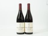 deux bouteilles de vin rouge posées sur une table blanche