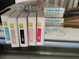 a lot of different colored ink cartridges sitting on a printer