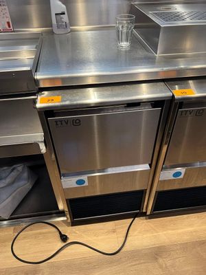 deux réfrigérateurs en acier inoxydable posés sur un plan de travail dans une cuisine