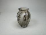 a white and black vase sitting on a white surface