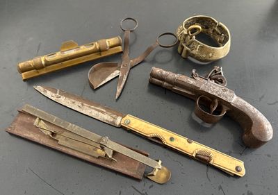 un pistolet, un couteau et d'autres objets posés sur une table