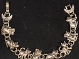 a silver bracelet with animals and birds on it
