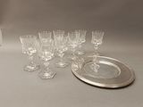 a lot of wine glasses and a silver plate on the table