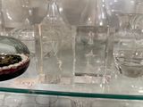 de nombreux vases en verre exposés sur une étagère en verre