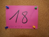 the number 18 is placed on a bulletin board with push pins