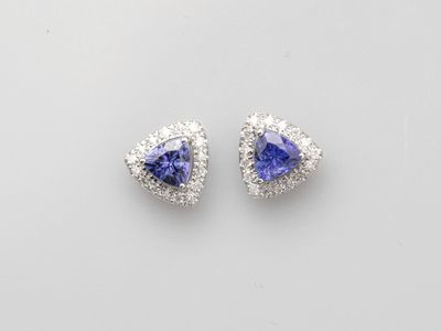 a pair of tan and white diamond earrings