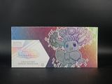 Quelqu'un tient une boîte de cartes à collectionner Pokémon posée sur une table.