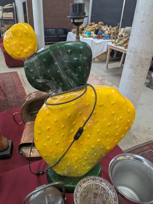 des vases jaunes et verts posés sur une table rouge dans une pièce