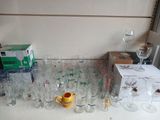 de nombreux verres et tasses posés sur la table, à côté d'une boîte de verres à vin