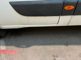 a small white car parked in a parking lot