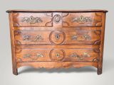 une commode en bois dont les tiroirs sont ornés de sculptures raffinées