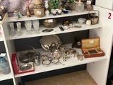 une étagère blanche sur laquelle sont posés des casseroles et des poêles, dans une pièce