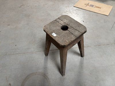 un petit tabouret en bois percé d'un trou