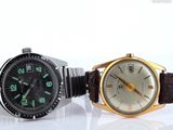 two watches sitting next to each other on a white surface