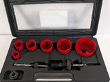 a set of red holesaws in a black case on a white surface