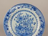 une assiette bleue et blanche ornée de fleurs et d'oiseaux