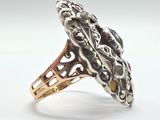 silver and gold ring with a green stone in the center