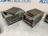 three old toasters are sitting on a table with a blue and white sign in the background