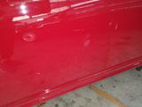 a close up of a red car that has a hole in it