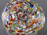 a close up of a colorful glass bowl on a metal stand
