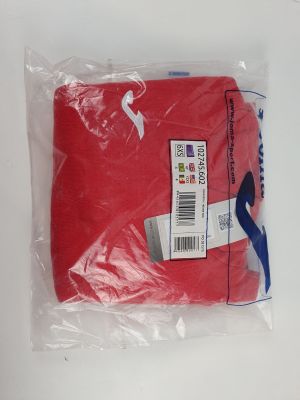 a red t - shirt wrapped in plastic on a table