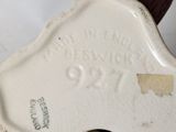 a close up of a white vase with a brown star on it