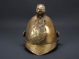 brass helmet on a black background with a lion head on it