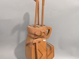 a wooden sculpture of a golf bag and clubs on display