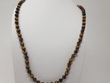 a tiger eye beaded necklace on a white mannequin