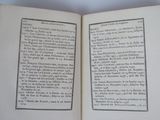 an open book with black writing on it on a table