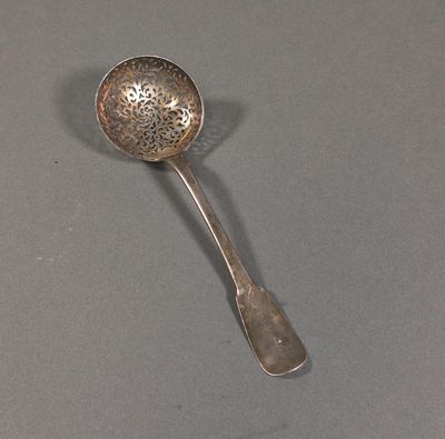 silver plated spoon with a flower design on it on a gray surface
