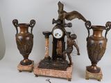 three vases and a clock sitting on a table