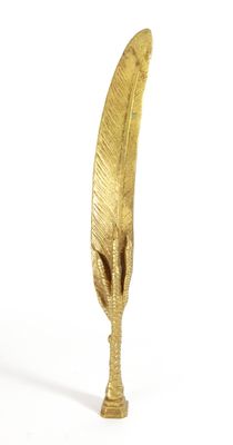 a gold feather shaped object on a white surface
