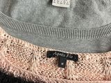 three sweaters are stacked on top of each other on a table
