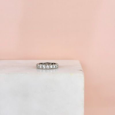 a white diamond ring sitting on top of a white marble block