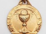 un gros plan d'une médaille d'or sur laquelle figure un calice