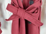 un gros plan sur un manteau rouge orné d'une cravate