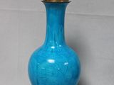 a blue glass lamp that is on a black base
