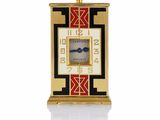 une image représentant une horloge dorée ornée d'un motif rouge et noir