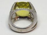 une bague ornée d'une pierre jaune sur un fond blanc