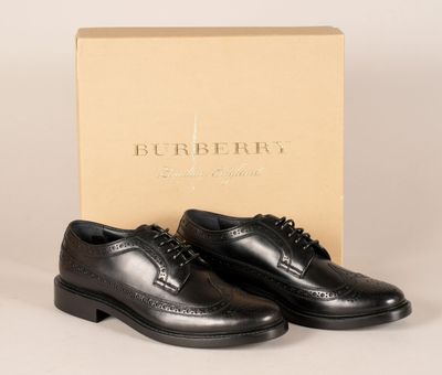 une paire de chaussures noires devant une boîte