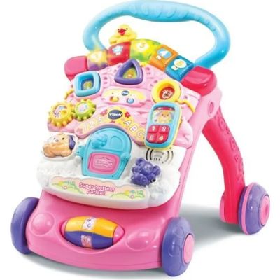 un trotteur rose pour bébé, surmonté de jouets, posé sur une surface blanche