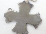 a silver cross that is on a white cloth