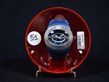 une montre bleue et rouge posée dans un écrin rouge