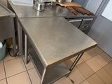 a stainless steel table in the middle of a kitchen