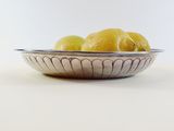 a bowl of lemons sitting on a white table