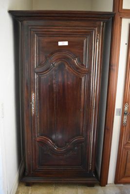 a tall wooden cabinet in the corner of a room