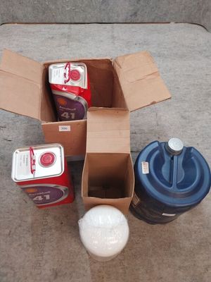 une boîte de nourriture et une canette de soda posées par terre