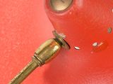 a small red object with a gold handle on a red surface