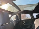 the sun shines through the sunroof over the back seats of a car